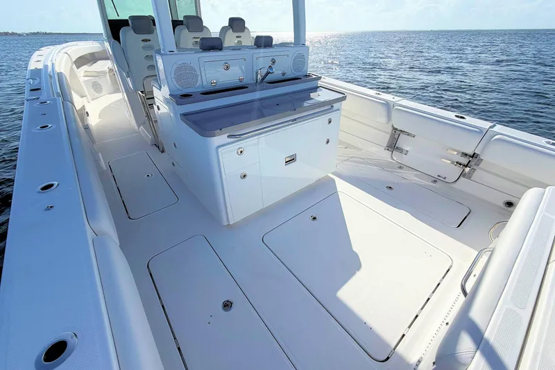 Slide: The Image of 2020 HCB 42 Siesta boat deck with seating and storage, on calm ocean waters. - 16