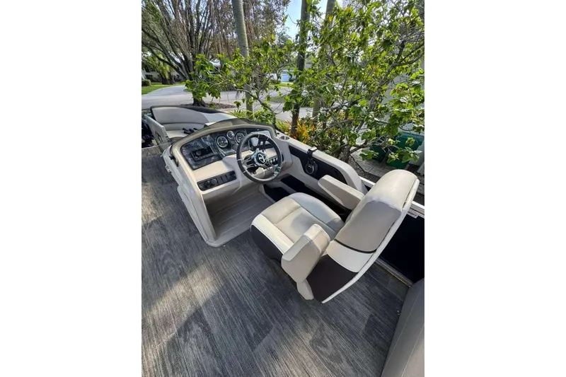 Slide: The Image of 2023 Tahoe Pontoon LTZ 2385 Quad Lounge interior with steering wheel and seating. - 1