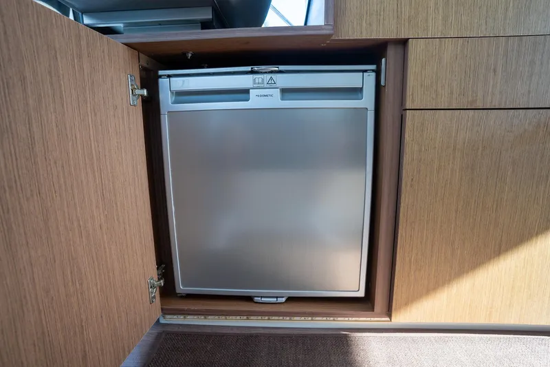 Slide: The Image of Built-in fridge in 2021 Beneteau Antares 9 boat interior, wooden cabinetry. - 31