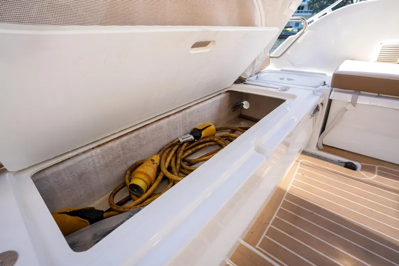 Slide: The Image of Storage compartment on 2021 Beneteau Antares 9 boat with coiled yellow cables. - 34