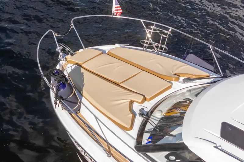 Slide: The Image of 2021 Beneteau Antares 9 boat with sunbathing cushions on deck, floating on water. - 8