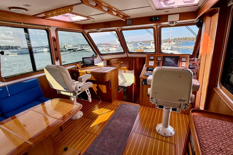 Slide: The Image of 2006 Sabre 42 Sedan interior with helm, seating, and panoramic windows overlooking marina. - 46