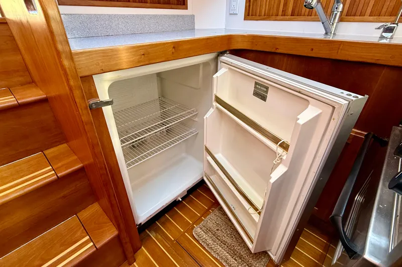 Slide: The Image of Open refrigerator in 2006 Sabre 42 Sedan yacht kitchen with wooden interior. - 41