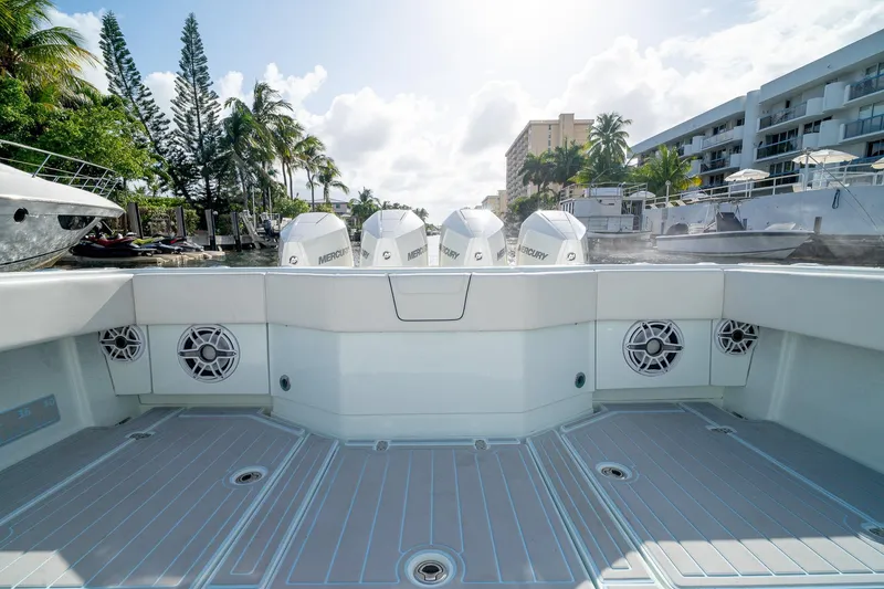 Slide: The Image of 2023 SeaVee 390Z boat deck with Mercury engines, docked near palm trees and buildings. - 18