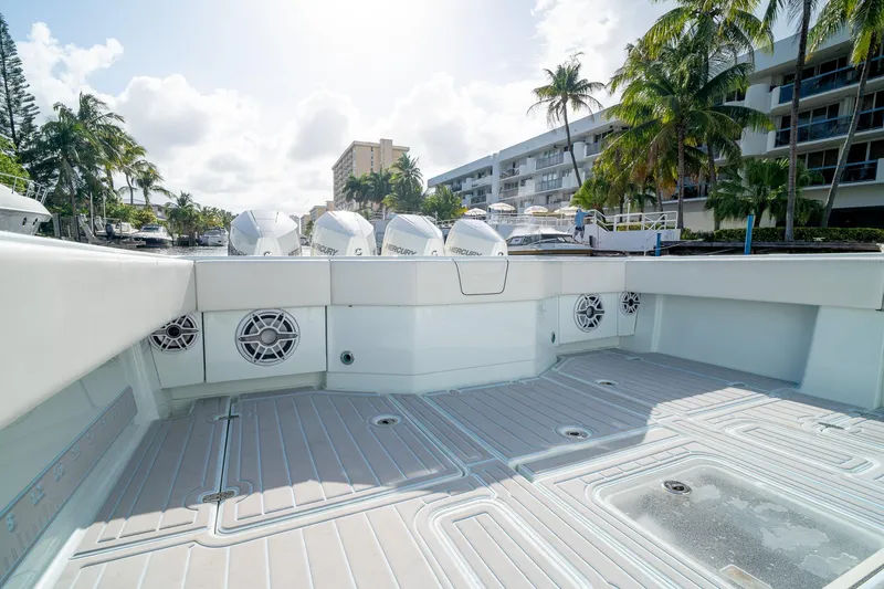 Slide: The Image of 2023 SeaVee 390Z boat deck with speakers and Mercury engines, docked near palm trees. - 19