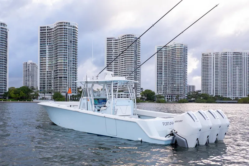 Slide: The Image of 2023 SeaVee 390Z boat on water with city skyline backdrop. - 2