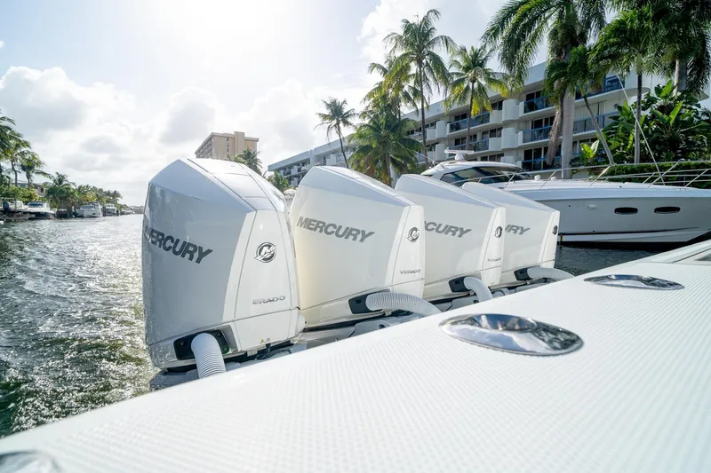 Slide: The Image of 2023 SeaVee 390Z boat with four Mercury engines docked near palm trees and buildings. - 20