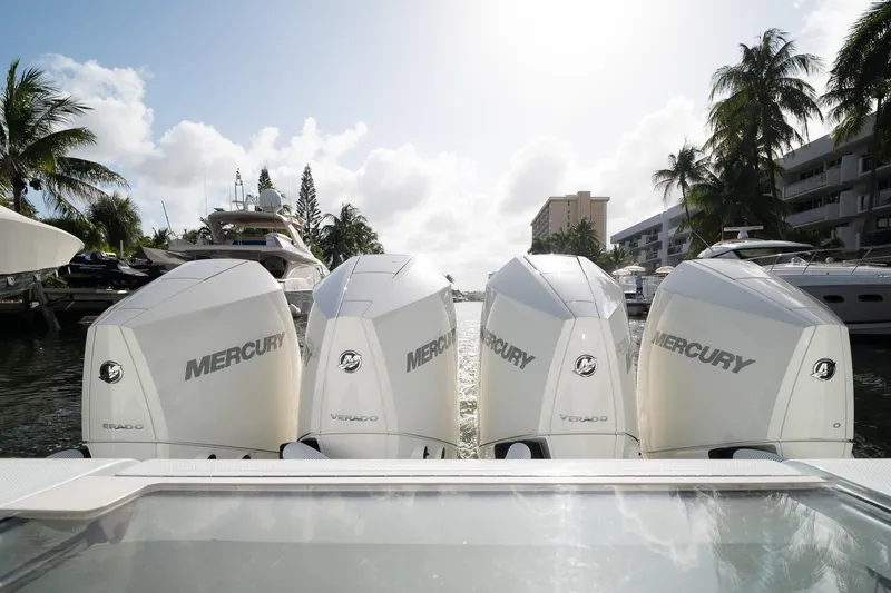 Slide: The Image of Four Mercury Verado engines on a 2023 SeaVee 390Z boat, docked near palm trees. - 21