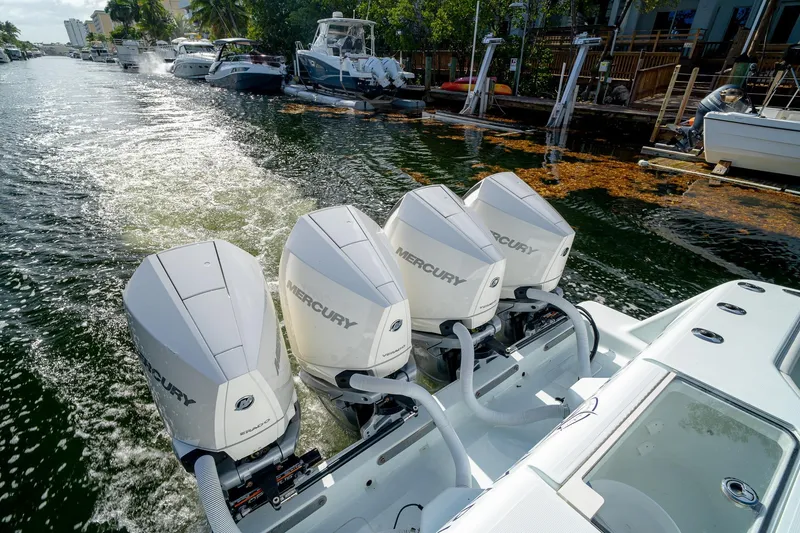Slide: The Image of 2023 SeaVee 390Z boat with four Mercury outboard engines on a sunny waterway. - 24