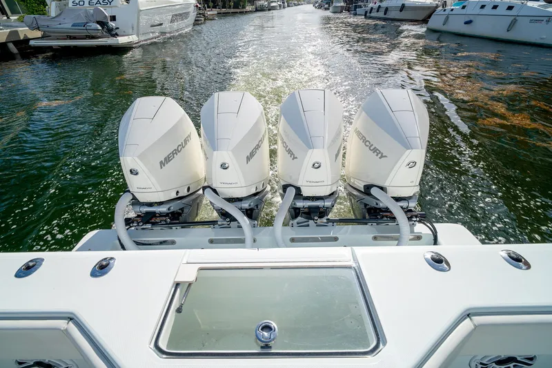 Slide: The Image of 2023 SeaVee 390Z boat with four Mercury outboard engines on a calm waterway. - 26