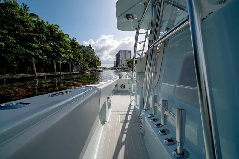Slide: The Image of 2023 SeaVee 390Z boat docked by lush greenery and waterfront buildings. - 35