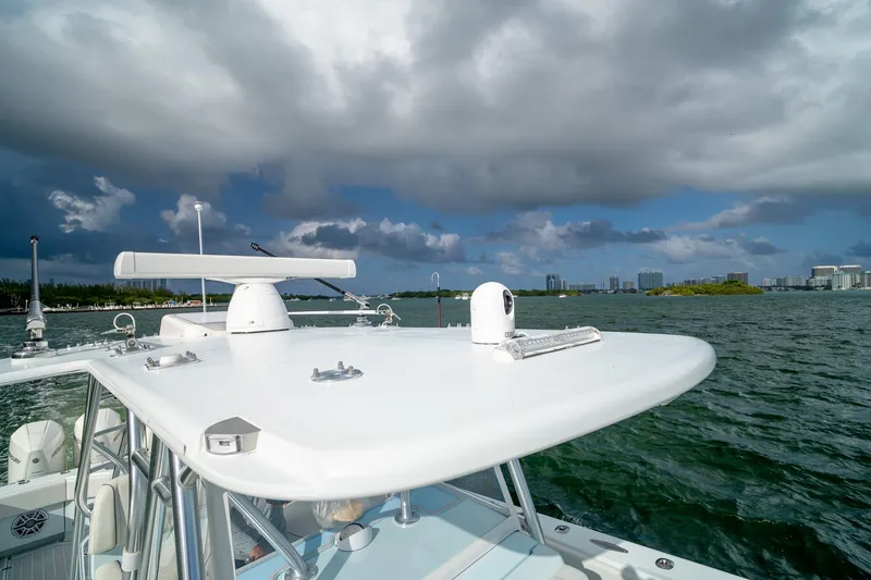 Slide: The Image of 2023 SeaVee 390Z boat on water under cloudy sky, cityscape in background. - 38