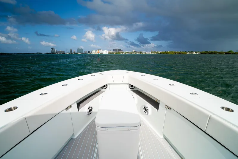 Slide: The Image of 2023 SeaVee 390Z boat cruising on open water with city skyline in background. - 49