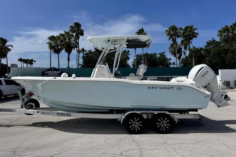 Slide: The Image of 2026 Key West 239 FS boat on trailer, parked outdoors under clear sky. - 1
