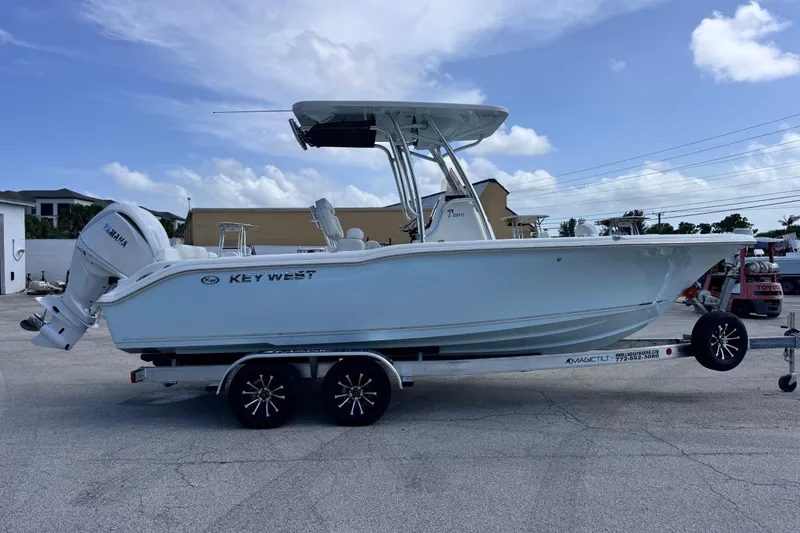 Slide: The Image of 2026 Key West 239 FS boat on trailer, featuring Yamaha engine, under clear blue sky. - 5
