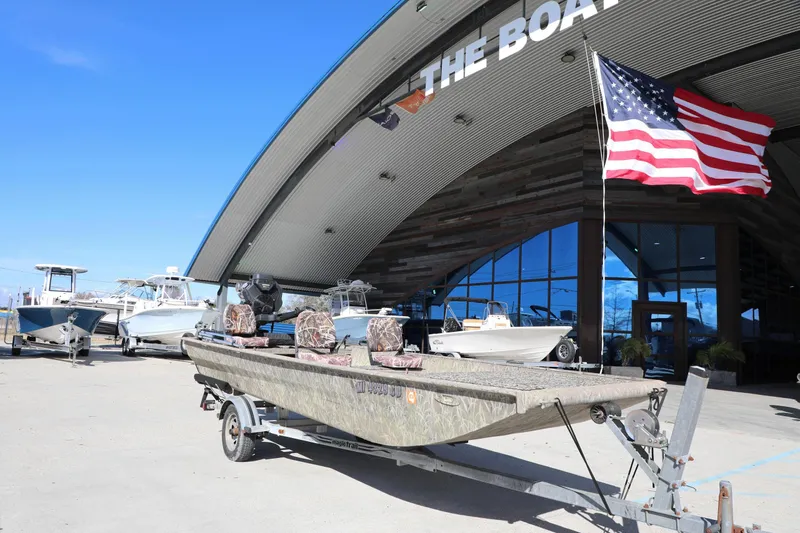 Slide: The Image of 2017 Gator Tail 16 boat on trailer outside showroom with American flag. - 12
