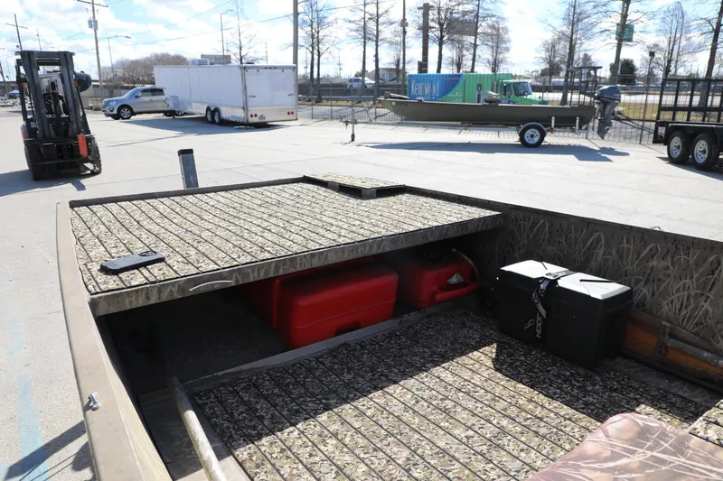 Slide: The Image of 2017 Gator Tail 16 boat with camo interior, parked near trailers and forklift. - 6