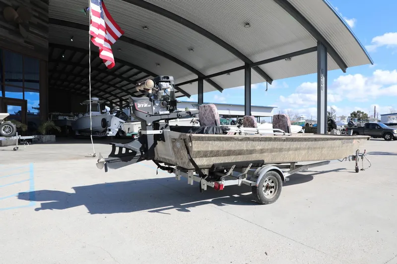 Slide: The Image of 2017 Gator Tail 16 boat on trailer outside dealership, American flag visible. - 7
