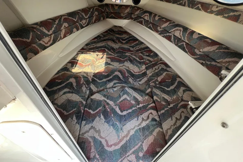 Slide: The Image of 1996 Rinker 232 Captiva Cuddy cabin interior with patterned upholstery. - 12