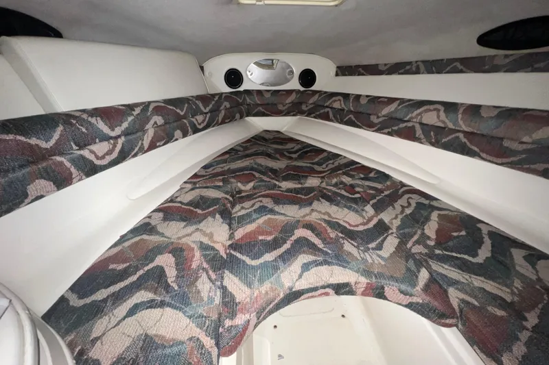 Slide: The Image of Interior of 1996 Rinker 232 Captiva Cuddy with patterned upholstery and compact design. - 13