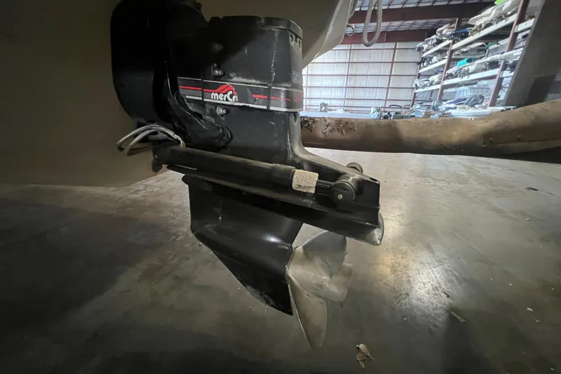 Slide: The Image of Close-up of a 1996 Rinker 232 Captiva Cuddy boat's MerCruiser outdrive in a storage facility. - 16