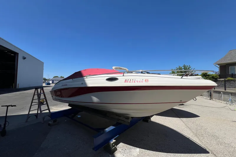 Slide: The Image of 1996 Rinker 232 Captiva Cuddy boat on trailer, red and white design, sunny day. - 3