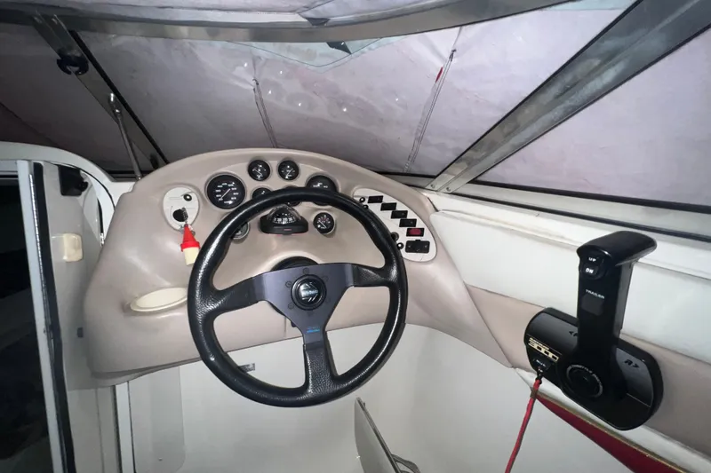 Slide: The Image of 1996 Rinker 232 Captiva Cuddy boat dashboard with steering wheel and control panel. - 8