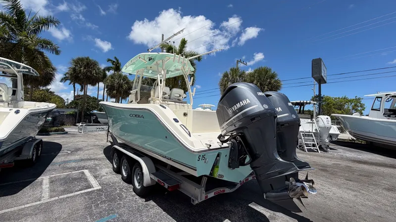 Slide: The Image of 2015 Cobia 296 Center Console boat with Yamaha engines on trailer. - 16