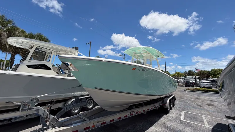 Slide: The Image of 2015 Cobia 296 Center Console boat on trailer under blue sky. - 18
