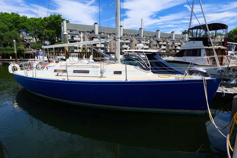 The Image of 1998 J Boats J/32 sailboat docked in a marina, featuring a sleek blue hull. - 0