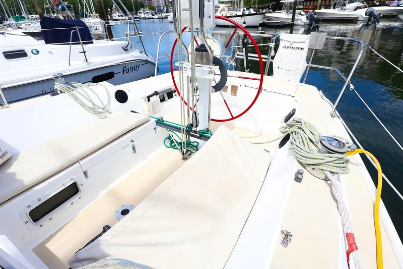 Slide: The Image of 1998 J Boats J/32 sailboat cockpit with red steering wheel, docked at marina. - 17