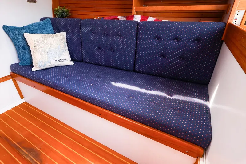 Slide: The Image of Interior of 1998 J Boats J/32 with blue cushioned seating and decorative pillows. - 25