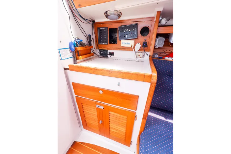Slide: The Image of 1998 J Boats J/32 interior navigation station with wooden cabinetry and control panel. - 34