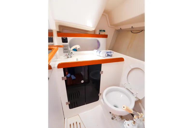 Slide: The Image of 1998 J Boats J/32 yacht bathroom with sink, toilet, and storage cabinets. - 37