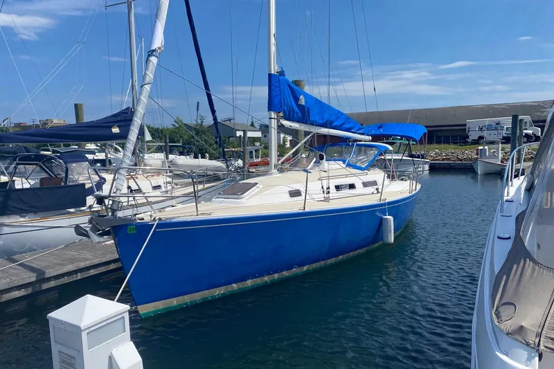Slide: The Image of 1998 J Boats J/32 sailboat docked in marina, featuring a vibrant blue hull. - 9