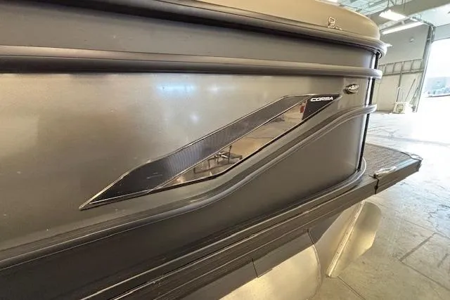 Slide: The Image of 2026 Barletta Corsa 23UC pontoon boat, sleek black exterior detail in a showroom. - 7