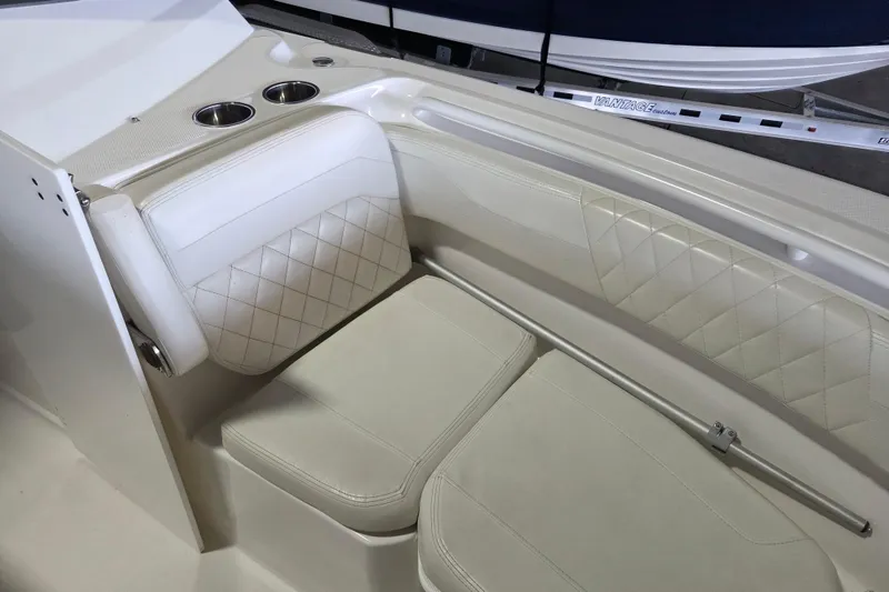 Slide: The Image of 2019 Edgewater 262CX Crossover boat interior with white cushioned seating and cup holders. - 10