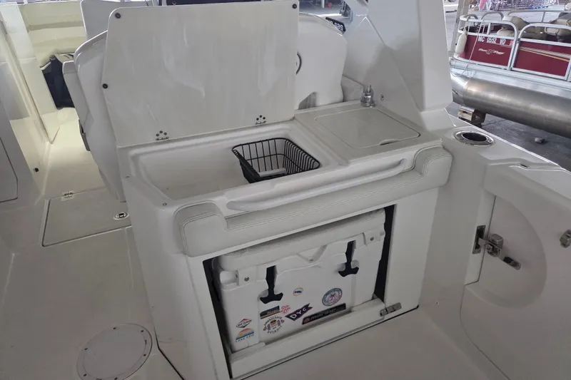 Slide: The Image of 2019 Edgewater 262CX Crossover boat interior with sink and storage area. - 16