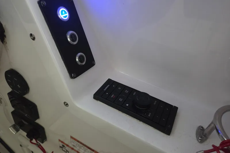 Slide: The Image of Control panel on 2019 Edgewater 262CX Crossover boat with illuminated buttons and switches. - 23