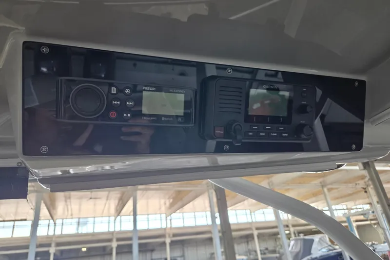 Slide: The Image of Control panel of a 2019 Edgewater 262CX Crossover boat featuring Fusion and Garmin devices. - 26