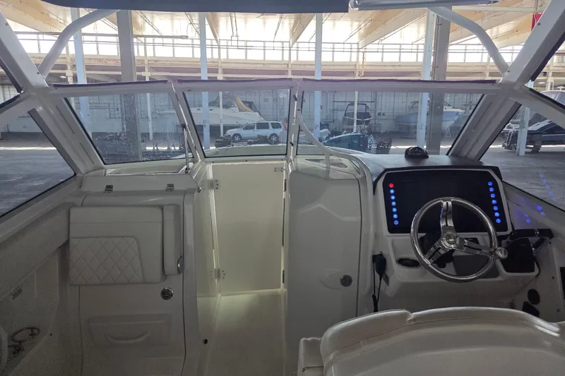 Slide: The Image of Interior view of 2019 Edgewater 262CX Crossover boat, featuring helm and seating area. - 27