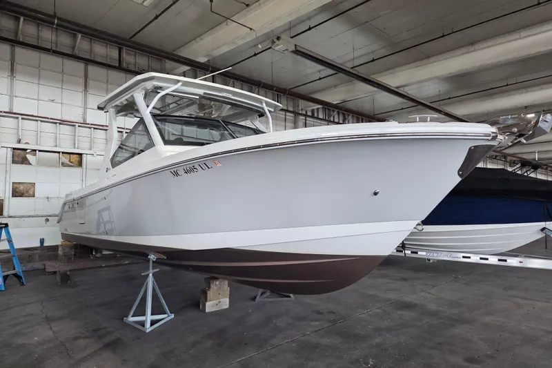 Slide: The Image of 2019 Edgewater 262CX Crossover boat in a warehouse, elevated on stands. - 29