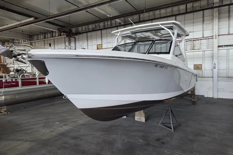 Slide: The Image of 2019 Edgewater 262CX Crossover boat in a warehouse setting. - 31