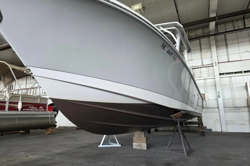 Slide: The Image of 2019 Edgewater 262CX Crossover boat in storage, viewed from below in a warehouse. - 32