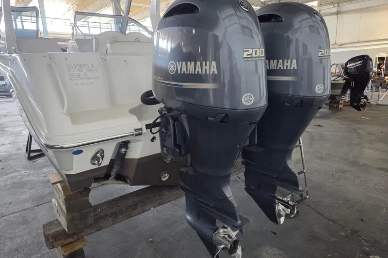 Slide: The Image of 2019 Edgewater 262CX Crossover boat with dual Yamaha 200 engines in a warehouse setting. - 7