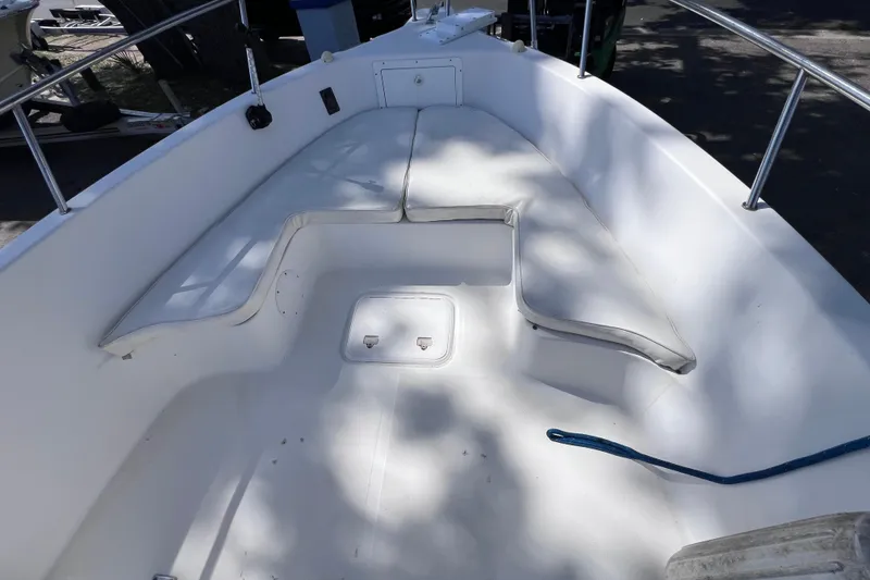 Slide: The Image of 2006 Pro-Line 23 Sport boat interior with cushioned seating and storage compartment. - 15