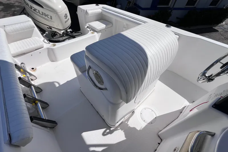 Slide: The Image of 2006 Pro-Line 23 Sport boat interior with Suzuki engine, featuring white seating and helm. - 19