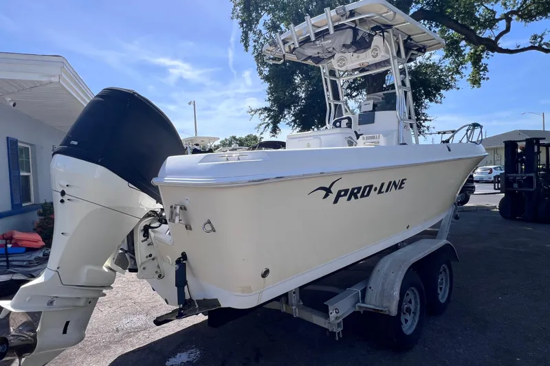 Slide: The Image of 2006 Pro-Line 23 Sport boat on trailer, featuring outboard motor and T-top. - 2
