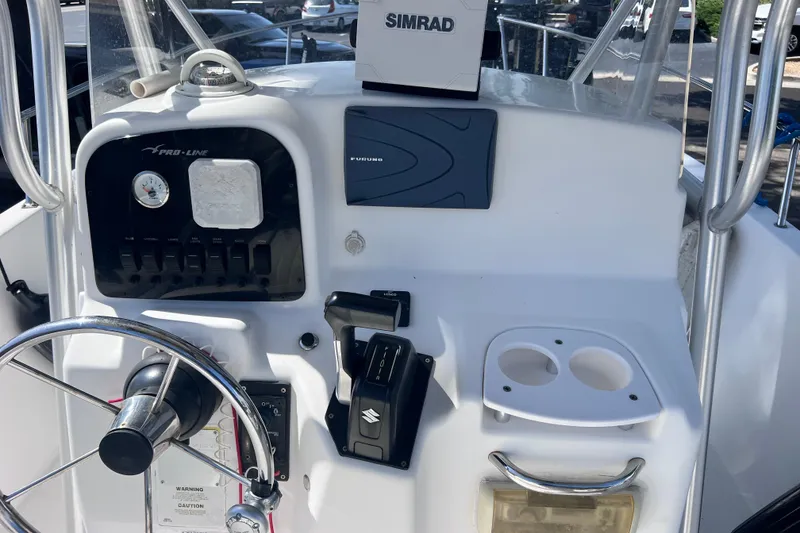 Slide: The Image of Control panel of a 2006 Pro-Line 23 Sport boat with steering wheel and electronics. - 21