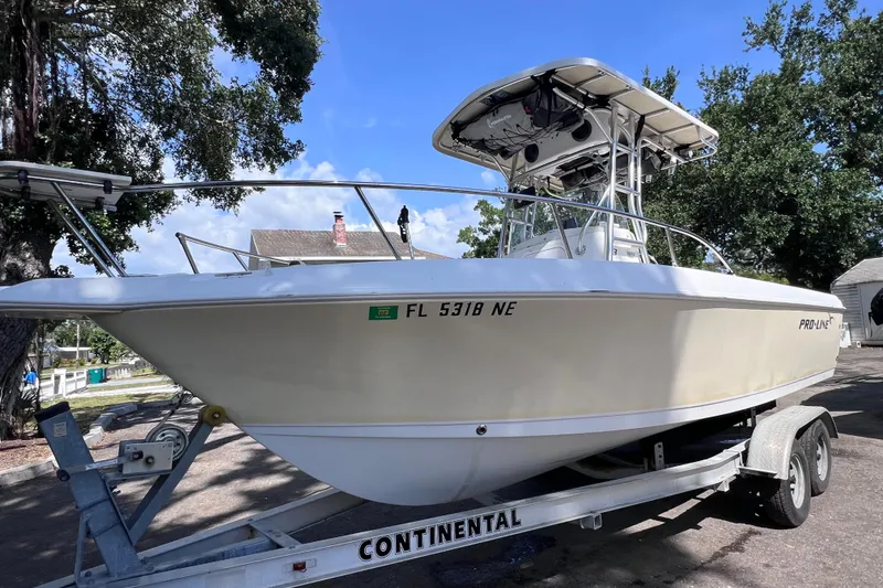 Slide: The Image of 2006 Pro-Line 23 Sport boat on trailer, parked outdoors under trees. - 7